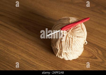 Zwei Knäuel Garn zum Stricken und Haken auf dem Tisch Stockfoto