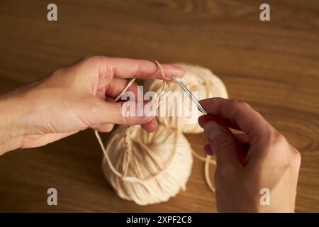 Zwei Knäuel Garn zum Stricken und Haken auf dem Tisch Stockfoto