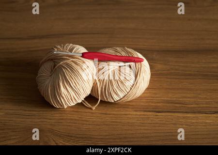 Zwei Knäuel Garn zum Stricken und Haken auf dem Tisch Stockfoto