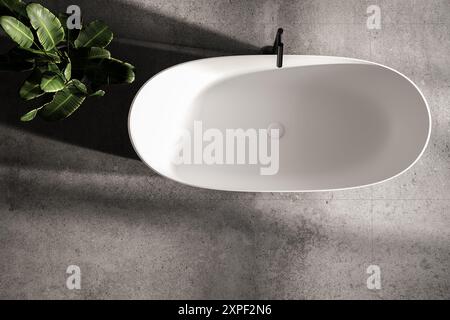 Blick von oben auf die weiße Badewanne auf Betonboden in modernem Bad und Pflanzen Stockfoto