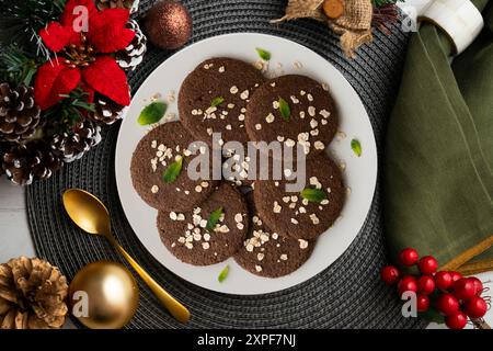 Köstliche vegane Schokoladenkekse mit Hafer auf einem Tisch mit weihnachtsdekoration. Stockfoto