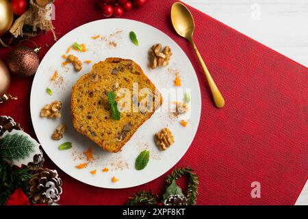 Leckeres Stück Karottenkuchen mit Walnüssen auf einem Tisch mit weihnachtsdekoration. Stockfoto