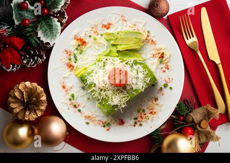 Gebackene Kartoffeln mit Spinat-Bechamel und Käse auf einem Tisch, der mit weihnachtsessen dekoriert ist. Stockfoto