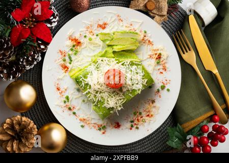 Gebackene Kartoffeln mit Spinat-Bechamel und Käse auf einem Tisch, der mit weihnachtsessen dekoriert ist. Stockfoto