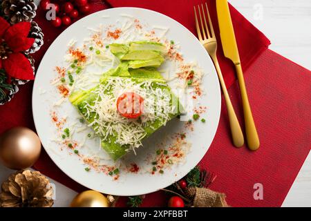 Gebackene Kartoffeln mit Spinat-Bechamel und Käse auf einem Tisch, der mit weihnachtsessen dekoriert ist. Stockfoto