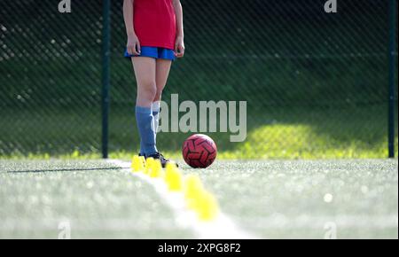 Mädchen Dribbelt Während Des Fußballtrainings Geschickt Ball Zwischen Flip Cups, Nahaufnahme Schuss Stockfoto