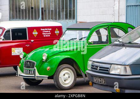 Hellgrüner klassischer citroen 2cv oder Deux Chevaux, der vor einer französischen Garage in frankreich geparkt ist Stockfoto