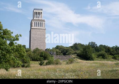 Der 50 Meter hohe Glockenturm auf dem Freiheitsplatz ist das größte Denkmal an ein Nazi-Konzentrationslager in Europa. Bronzestatue im Vordergrund Stockfoto