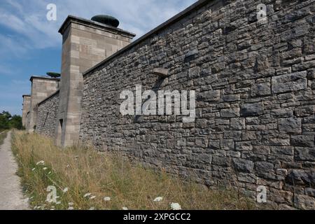 Gedenkstätte Buchenwald bei Weimar. Außenseite der Mauer mit Pylonen, auf denen regelmäßig Feuerschalen auf der neoklassischen „Straße der Nationen“ für nati beleuchtet werden Stockfoto