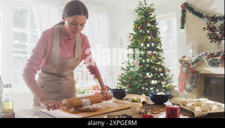 Porträt der Küchenchefin, die Teig zubereitete und Lebkuchen zu Weihnachten zuhause zubereitete. Fröhliche Kleinunternehmer-Eigentümerin, die hausgemachtes Gebäck für ihren Shop herstellt Stockfoto