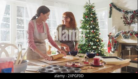 Porträt der erwachsenen Mutter und Tochter, die das Weihnachtsessen für Gäste vorbereiten. Schöne Frau und ihre Seniormutter binden sich beim Kochen, Reden, Zeit zusammen an Feiertagen Stockfoto