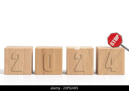 Holzwürfel mit Inschrift 2024 und Stoppschild auf weißem Hintergrund Stockfoto