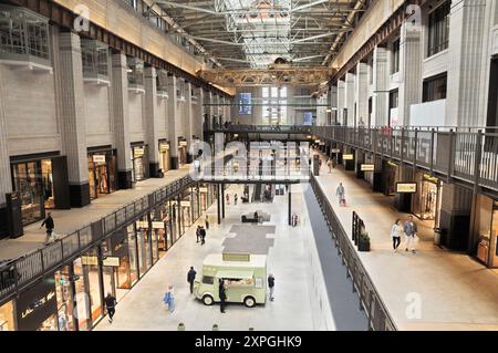 Das Innere der Battersea Power Station Entwicklung mit Besuchern von Geschäften und Restaurants in Turbine Hall, Einem Einkaufszentrum, London, UK Retail Stockfoto