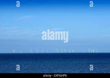Eine Reihe von Windturbinen auf See am Horizont auf einem Offshore-Windpark vor der englischen Küste, der erneuerbare Energie erzeugt. Kent, England, Großbritannien. Windparks Stockfoto