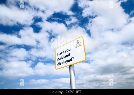 „Haben Sie bezahlt und angezeigt?“ Schilder. Parkschild gegen blauen Himmel und Wolken, Cornwall, England, Großbritannien Stockfoto