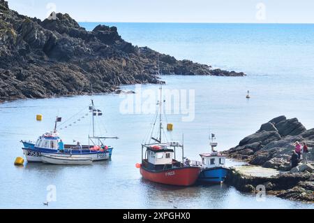 Traditionelle Fischerboote in der Nähe der Mündung des Hafens Polperro, die auch als Transport für touristische Bootsausflüge an der Küste Cornwalls dienen. Cornwall Großbritannien Stockfoto
