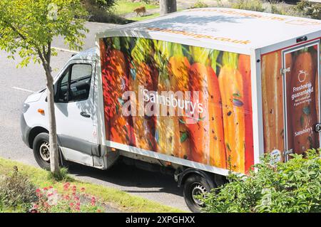 Sainsburys Lieferwagen parkte vor einem Haus in einer britischen Vorstadtstraße. Lieferwagen, Einkaufslieferungen, Lebensmittel, Lieferservice nach Hause Stockfoto