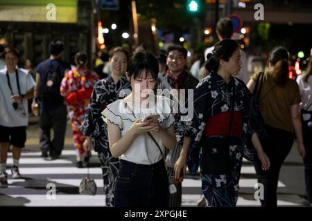 Tokio, Japan. August 2024. Fußgänger gehen nach Sonnenuntergang über eine Kreuzung. Neben den farbenfrohen, lebhaften und immer geschäftigen touristischen Hotspots wie Shibuya und Shinjuku bietet Tokio auch ruhigere und authentischere Gegenden, in denen Touristen lokale Küche genießen und echte Erfahrungen mit den Einheimischen machen können. Ein Beispiel für einen solchen Ort ist der alte Tsukiji Fischmarkt in der Nähe von Ginza. Quelle: SOPA Images Limited/Alamy Live News Stockfoto