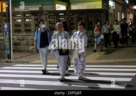 Tokio, Japan. August 2024. Senioren in Yukata gehen über eine Fußgängerüberquerung. Neben den farbenfrohen, lebhaften und immer geschäftigen touristischen Hotspots wie Shibuya und Shinjuku bietet Tokio auch ruhigere und authentischere Gegenden, in denen Touristen lokale Küche genießen und echte Erfahrungen mit den Einheimischen machen können. Ein Beispiel für einen solchen Ort ist der alte Tsukiji Fischmarkt in der Nähe von Ginza. (Foto: Stanislav Kogiku/SOPA Images/SIPA USA) Credit: SIPA USA/Alamy Live News Stockfoto