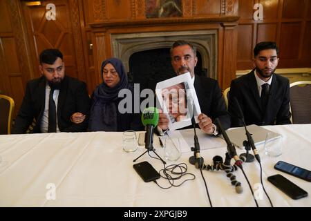 Rechtsanwalt Aamer Anwar (2. Rechts) mit Brüdern, Muhammad Amaad, 25, (links) Fahir Amaaz, 19, und ihre Mutter Shameem Akhtar, 56, hält ein Bild hoch, das Frau Akhtar während einer Pressekonferenz im Midland Hotel in Manchester eine Verletzung zeigt, als sie mit dem IOPC gesprochen haben, "was die Einreichung einer formellen Beschwerde gegen Beamte betrifft". Proteste brachen im Stadtzentrum von Rochdale und Manchester aus, nachdem ein Video von einem Polizisten, der angeblich einen Mann trat und auf ihn stieß, während er während einer Verhaftung am Flughafen am 23. Juli verdeckt lag. Bilddatum: Dienstag, 6. August 2024. Stockfoto