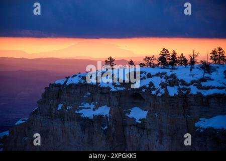 Atemberaubendes Bild der schneebedeckten Klippen im Bryce Canyon National Park. Der wunderschöne pastellfarbene Sonnenaufgang bildet einen dramatischen Kontrast zum weißen Schnee. Stockfoto