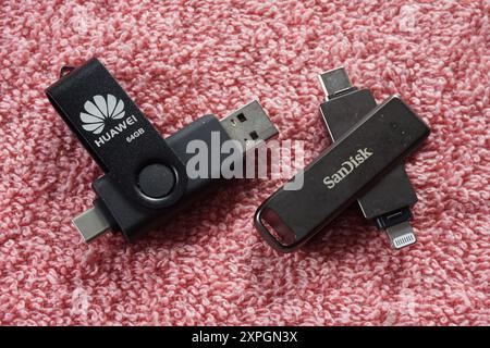 Terengganu, Malaysia - 24. August 2024 : Nahaufnahme von sandisk otg Dual Drive und huawei otg Dual Drive auf rotem Hintergrund Stockfoto