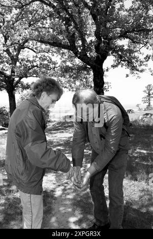 Kaukasischer Mann im Alter von 50 bis 55 Jahren, der sich die Hände mit einer Flasche Wasser gewaschen hat, das von einer Frau auf dem Weg im Petit Jean State Park in der Nähe von Morrilton, Arkansas, gegossen wurde. Stockfoto