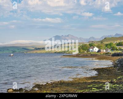 Das wunderschöne Dorf Carbost am Ufer von Loch Harport mit seiner atemberaubenden Kulisse der Cuillin Hills. Stockfoto