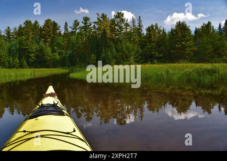 Gelbes Seekajak auf Süßwassersee kleine Passage. Ruhiges Wasser am Wapizagonke Lake Canada Park La Mauricie, Quebec, Kanada. Sonniger Tag perfekt zum Polstern Stockfoto