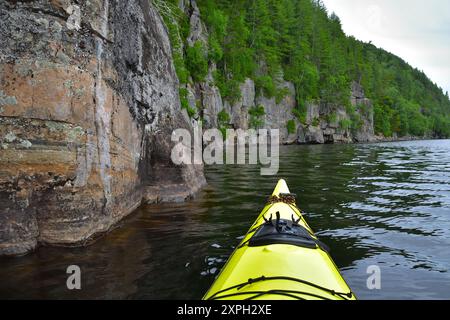 Gelbes Seekajak auf einem See mit Felsenwand. Wapizagonke Lake Canada Park La Mauricie, Quebec, Kanada. Ruhiger Tag zum Paddeln. Stockfoto