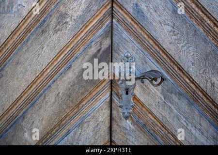 . Altes, rustikales Muster und Details der Eingangstür aus Hartholz. Nahaufnahme, altes Metallschloss, keine Leute. Stockfoto
