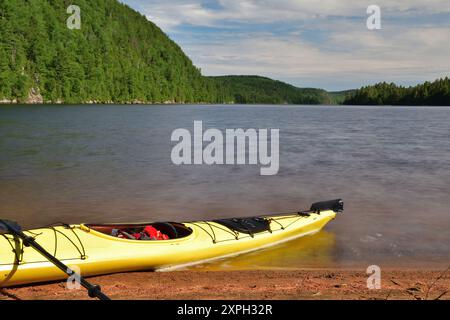 Gelbes Kajak am Sandstrand am See Wapizagonke. Canada Park La Mauricie, Quebec, Kanada. Sommerpaddeltag. Lange Belichtung Stockfoto