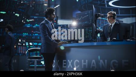 Finanzanalyst mit einem Desktop-Computer mit Multi-Monitor Workstation mit Echtzeit-Diagrammen, Finanzberichten und Marktdiagrammen. Indischer Händler, der in einem modernen Börsengeschäft arbeitet Stockfoto