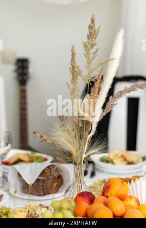 Hochzeitsbankett im Restaurant, überdachter runder Tisch für Gäste, weiße Teller mit Obst und Snacks. Stockfoto