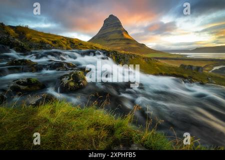 Panoramablick auf den Berg Kirkjufell in Island mit dem Rider im Vordergrund, lange Exposition, Sonnenaufgang, schöne Wolken Stockfoto