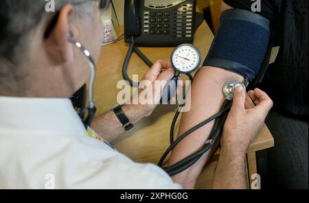 Aktenfoto vom 29/07/24 eines Arztes, der den Blutdruck eines Patienten im Temple Fortune Health Centre in der Nähe von Golders Green, London, überprüft. Patienten werden als Ergebnis von „unnötigen“ Arbeitskampfmaßnahmen von GPS „bestraft“, und andere Teile des NHS werden als Ergebnis einer kollektiven Aktion von Hausärzten „die Stücke abholen“ überlassen, sagte Gesundheitsminister Wes Streeting. Ausgabedatum: Dienstag, 6. August 2024. Stockfoto