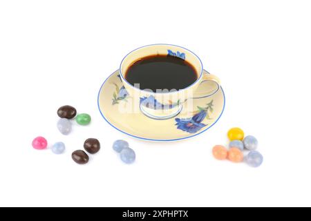 Kaffee in Vintage Porzellan Tasse und Dragee Bonbons isoliert auf weißem Hintergrund. Stockfoto