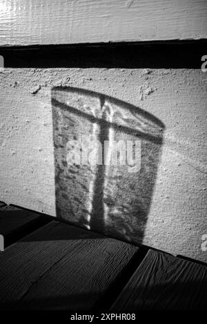 Abstrakter Schatten aus einem Glas, leere Hintergrundkomposition zur Produktpräsentation. Schwarzweißbild. Strukturiert. Stockfoto