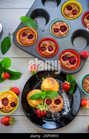 Süße Quark-Muffins mit Erdbeerfüllung, auf einem Teller auf einem Holztisch. Stockfoto