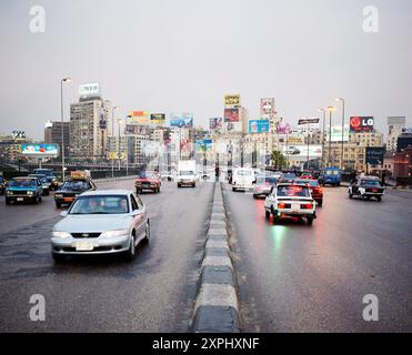 Eine geschäftige Szene, aufgenommen von der 6. Oktober-Brücke in Kairo, Ägypten, 2006. Zeigt den starken Verkehr und die lebhafte Skyline der Stadt mit zahlreichen Anzeigen und Plakaten. Stockfoto