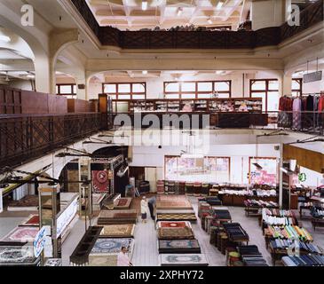 Das Innere des historischen Kaufhauses Hannaux in Alexandria, Ägypten, zeigt seine große Auswahl an Waren, darunter Teppiche und Textilien, unter warmer, geräumiger Beleuchtung, die 2006 aufgenommen wurde. Stockfoto