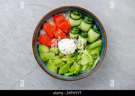 Hawaiianische Lachs Poke Schüssel mit Avocado, Draufsicht, grauer Hintergrund Stockfoto