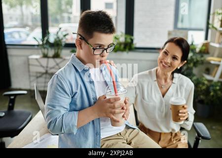 Eine Mutter arbeitet in ihrem Büro neben ihrem Sohn mit Down-Syndrom und demonstriert Inklusivität und Liebe. Stockfoto