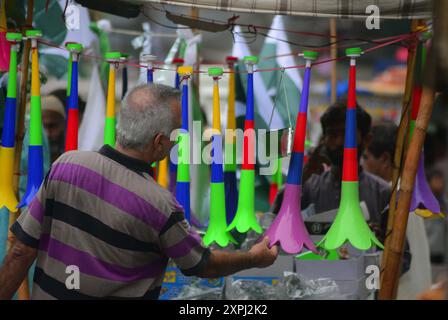 Pakistanische Flaggen, Buntstricke, bedruckte Hemden und andere Artikel werden am Dienstag, den 6. August 2024, an Straßenständen am Papiermarkt in Karachi verkauft. Stockfoto