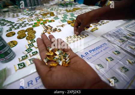 Pakistanische Flaggen, Buntstricke, bedruckte Hemden und andere Artikel werden am Dienstag, den 6. August 2024, an Straßenständen am Papiermarkt in Karachi verkauft. Stockfoto