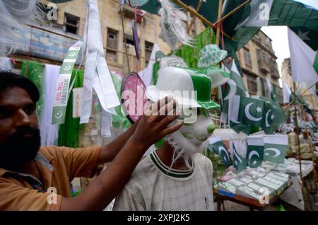 Pakistanische Flaggen, Buntstricke, bedruckte Hemden und andere Artikel werden am Dienstag, den 6. August 2024, an Straßenständen am Papiermarkt in Karachi verkauft. Stockfoto