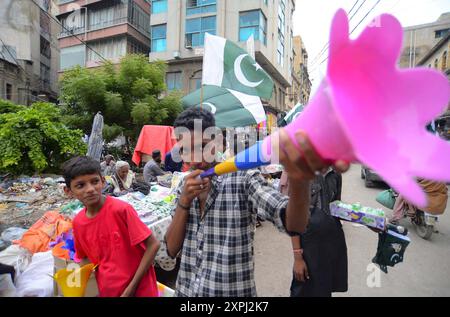 Pakistanische Flaggen, Buntstricke, bedruckte Hemden und andere Artikel werden am Dienstag, den 6. August 2024, an Straßenständen am Papiermarkt in Karachi verkauft. Stockfoto