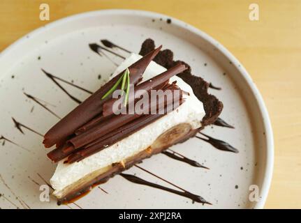 Ein Stück köstlicher Banoffee Pie serviert auf einem Holztisch Stockfoto