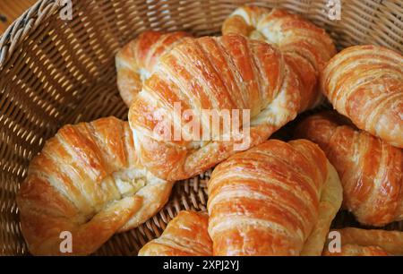 Jede Menge köstlicher frisch gebackener Croissants in einem Korb Stockfoto