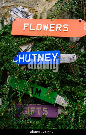 Grassington Yorkshire Großbritannien - 27. Juli 2024. Farbenfrohe Schilder zwischen üppigem Grün und Blumen, Chutney, Marmelade und Geschenke. Stockfoto